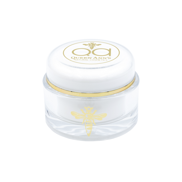 A white jar with gold logo on top of it.
